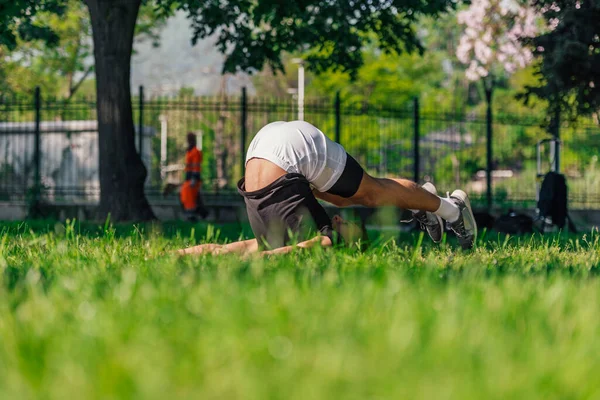 年轻健康英俊的男子在公园里练习瑜伽 做犁地姿势 — 图库照片