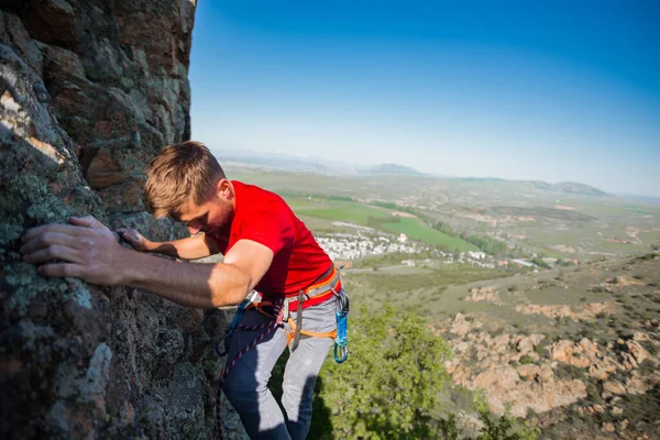 岩壁に登る練習をする強い幸せな男性登山家 — ストック写真