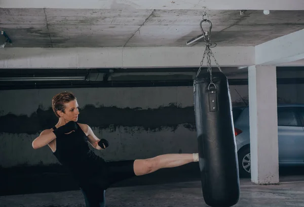 Mujer Caucásica Ropa Deportiva Con Vendajes Negros Pateando Bolsa Boxeo — Foto de Stock