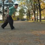Каскадёр Паркур практикуется в парке, прыгая через препятствие.