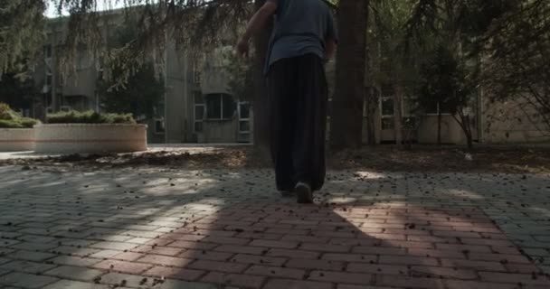 木から飛び降りながら駐車場を練習する男 アクション後のカメラ — ストック動画