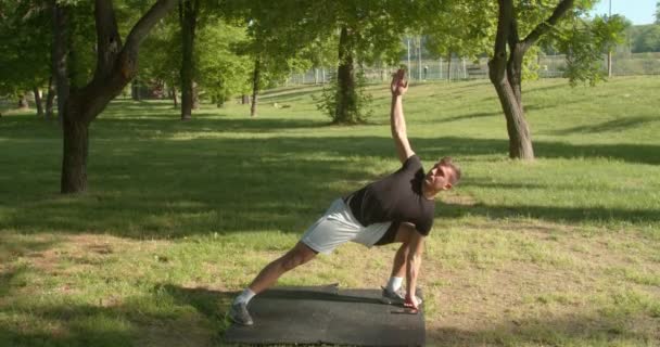 Sportlicher Junger Mann Praktiziert Yoga Park — Stockvideo