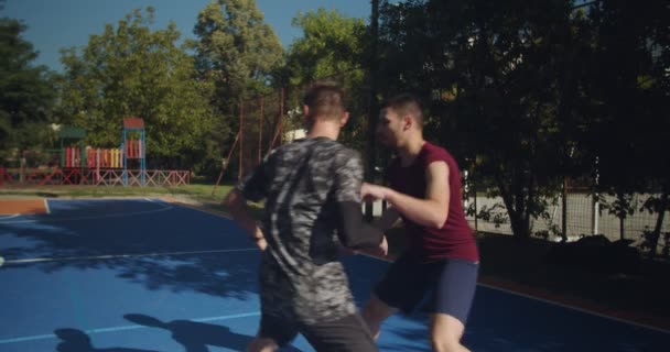 晴れた日にバスケットボールをしている4人の若い友人 — ストック動画