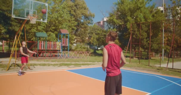 太陽の下でバスケットボールの試合のために暖まる友人 — ストック動画