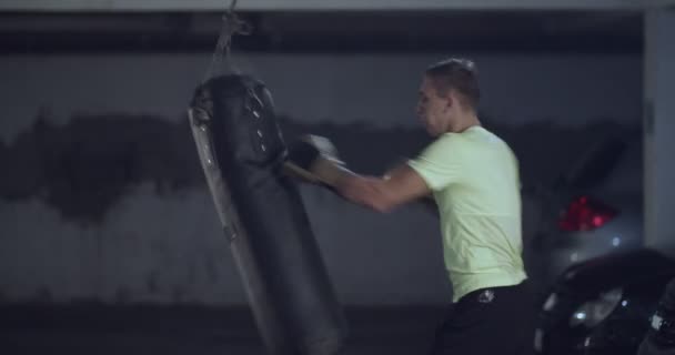 男选手在拳击室打了一个巨大的拳击袋 男子拳击手刻苦训练 — 图库视频影像