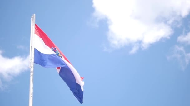 Флаг Хорватии, размахивающий ветром против голубого неба летом — стоковое видео
