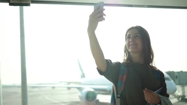 美しい女の子が空港ターミナルで selfie - フライトを待っています。 — ストック動画
