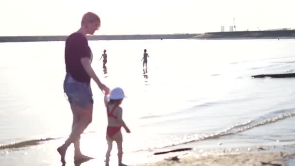 Moeder en dochter lopen en spelen op het strand — Stockvideo