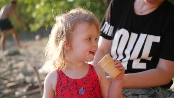 Little girl eat ice cream on beach — Stock Video