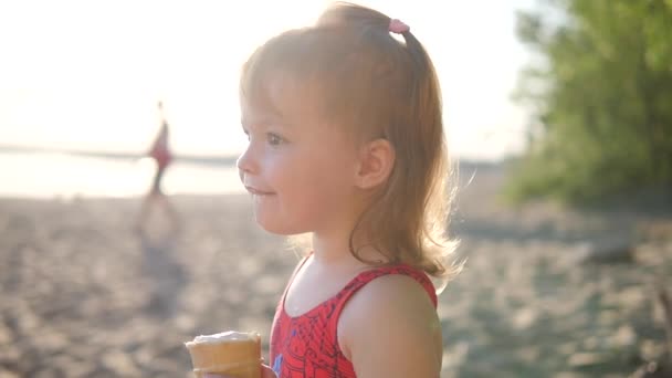 Küçük kız plajda dondurma yemek — Stok video