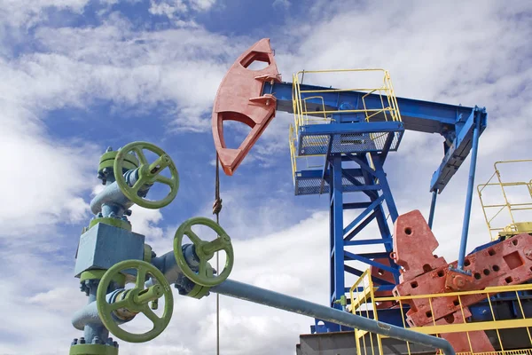 石油工业 天然气工业 油泵和绿色的闩锁 蓝蓝的天空 图库照片
