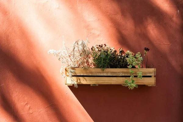 An old wooden box with flowers hanging on the wall.