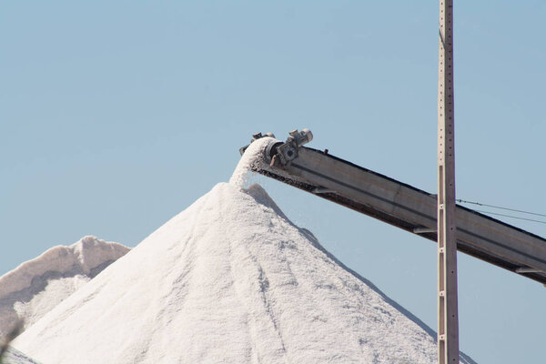 Salt production. Salt mountains against the blue sky.