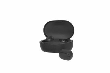 Şarj çantasının yanındaki siyah kablosuz kulaklıklar. Beyaz arka planda izole edilmiş modern kablosuz kulaklıklar..