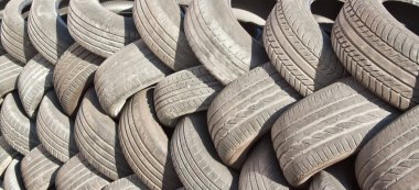 Eski araba lastiklerinin arka planı at kuyruğu şeklinde dizilmiş..