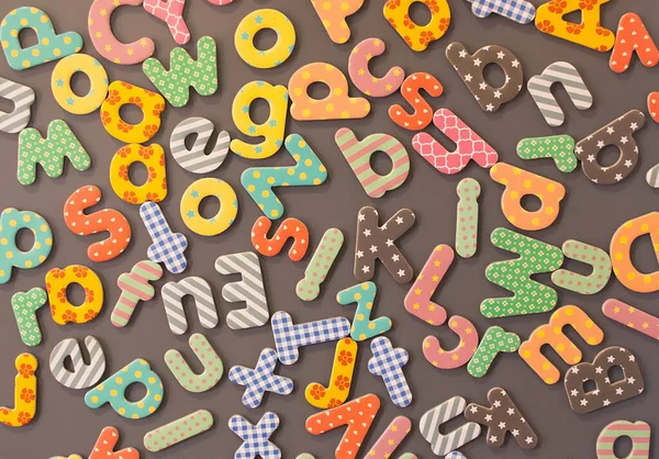 Colored Children Cardboard Letters Randomly Scattered Brown Background — Stock Photo, Image