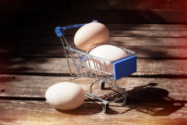 Kippeneieren Een Mini Speelgoedkarretje Voor Supermarkt Een Houten Ondergrond — Stockfoto