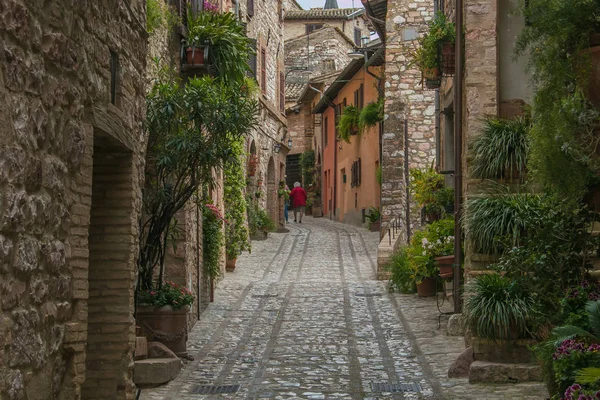 Spello, İtalya - 11 Mayıs 2019: Umbria'daki ortaçağ caddesi Spello için yürüyen yaşlı kadın