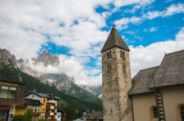SAN MARTINO DI CASTROZZZA, ITALY - 21 Temmuz 2020: Çan kulesiyle San Martino di Castrozza 'nın tarihi merkezinin yaz manzarası, İtalya' nın Trentino ilindeki Primiero vadisinde bir dağ beldesi