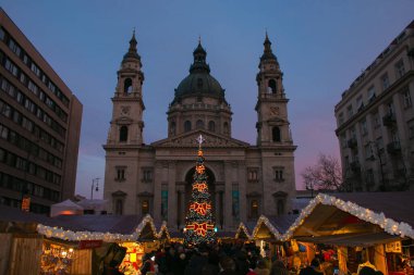 BUDAPEST, HUNGARY - 30 ARALIK 2019: Budapeşte katedrali yakınlarında gün batımında Noel pazarı