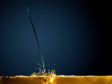 Close-up of oil and liquid pouring on dark background. clipart