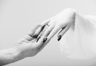 Eller erkek ve kadın birbirine gri arka plan üzerinde ulaşan. Siyah ve beyaz fotoğraf