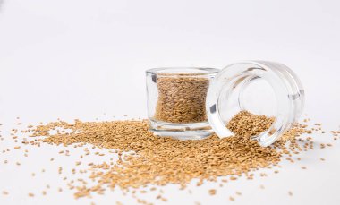 beyaz zemin üzerinde bir cam kavanoza dağınık bir tohumların üstten görünüm