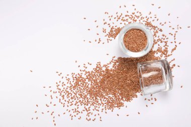 beyaz zemin üzerinde bir cam kavanoza dağınık bir tohumların üstten görünüm