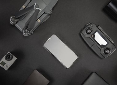 Çalışma alanı fotoğrafçı ile dizüstü bilgisayar, dijital kamera, bellek kartı, kamera, dron, uzaktan kumanda, telefon, Vr gözlük ve Fotoğrafçılık. Üstten görünüm siyah tablo arka plan üzerinde. Mockup şablon kavramı.