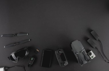 Alan profesyonel fotoğrafçı uçuş kiti quadcopter Vr gözlük ve fotoğrafçılık ile çalışmak. Üstten görünüm siyah tablo arka plan üzerinde. Mockup şablon kavramı.