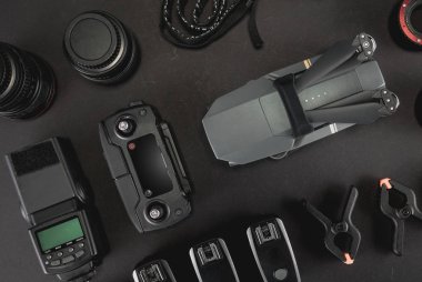 Çalışma alanı fotoğrafçı ile dizüstü bilgisayar, dijital kamera, bellek kartı, kamera, dron, uzaktan kumanda, telefon, Vr gözlük ve Fotoğrafçılık. Üstten görünüm siyah tablo arka plan üzerinde. Mockup şablon kavramı.