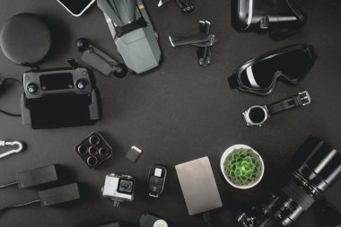Alan profesyonel fotoğrafçı uçuş kiti quadcopter Vr gözlük ve fotoğrafçılık ile çalışmak. Üstten görünüm siyah tablo arka plan üzerinde. Mockup şablon kavramı.