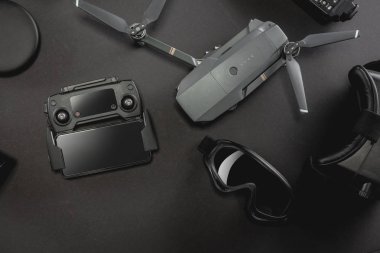 Çalışma alanı fotoğrafçı ile dizüstü bilgisayar, dijital kamera, bellek kartı, kamera, dron, uzaktan kumanda, telefon, Vr gözlük ve Fotoğrafçılık. Üstten görünüm siyah tablo arka plan üzerinde. Mockup şablon kavramı.