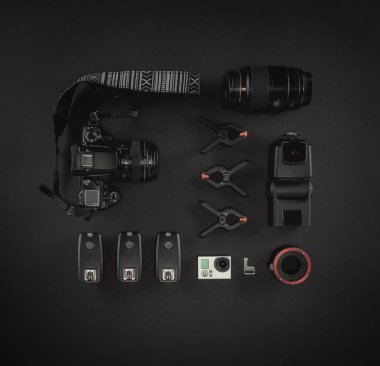 Çalışma alanı fotoğrafçı ile dizüstü bilgisayar, dijital kamera, bellek kartı, kamera, dron, uzaktan kumanda, telefon, Vr gözlük ve Fotoğrafçılık. Üstten görünüm siyah tablo arka plan üzerinde. Mockup şablon kavramı.