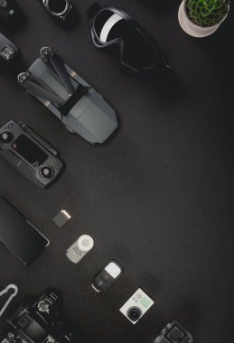 Alan profesyonel fotoğrafçı uçuş kiti quadcopter Vr gözlük ve fotoğrafçılık ile çalışmak. Üstten görünüm siyah tablo arka plan üzerinde. Mockup şablon kavramı.
