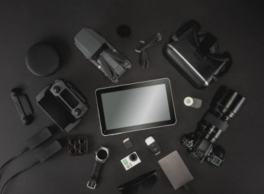 Çalışma alanı fotoğrafçı ile dizüstü bilgisayar, dijital kamera, bellek kartı, kamera, dron, uzaktan kumanda, telefon, Vr gözlük ve Fotoğrafçılık. Üstten görünüm siyah tablo arka plan üzerinde. Mockup şablon kavramı.