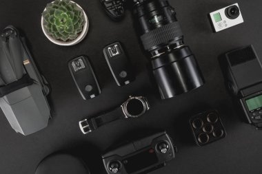 Çalışma alanı fotoğrafçı ile dizüstü bilgisayar, dijital kamera, bellek kartı, kamera, dron, uzaktan kumanda, telefon, Vr gözlük ve Fotoğrafçılık. Üstten görünüm siyah tablo arka plan üzerinde. Mockup şablon kavramı.