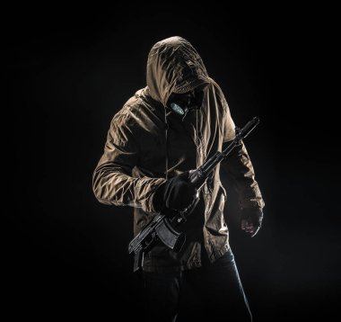 Maske ve koyu arka plan makinalı tüfek ile tehlikeli silahlı terör. Terör ve şiddet kavramı.