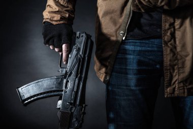 Maske ve koyu arka plan makinalı tüfek ile tehlikeli silahlı terör. Terör ve şiddet kavramı.