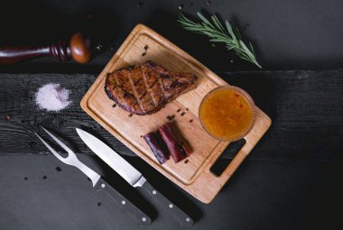 Biber, soğan ile lezzetli Çiğ domuz biftek. Et ve biberiye ahşap arka plan üzerinde. Lezzetli domuz biftek biber, Solta ve sauses. Et ve biberiye ahşap arka plan üzerinde.