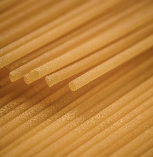 Macro surface closeup of uncooked pasta background. Studio photo shooting.