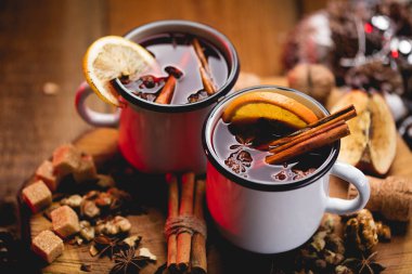 Baharatlar ve narenciye meyve ahşap yüzey üzerinde beyaz rustik kupalar sıcak mulled şarap. Hamur metin için yer.