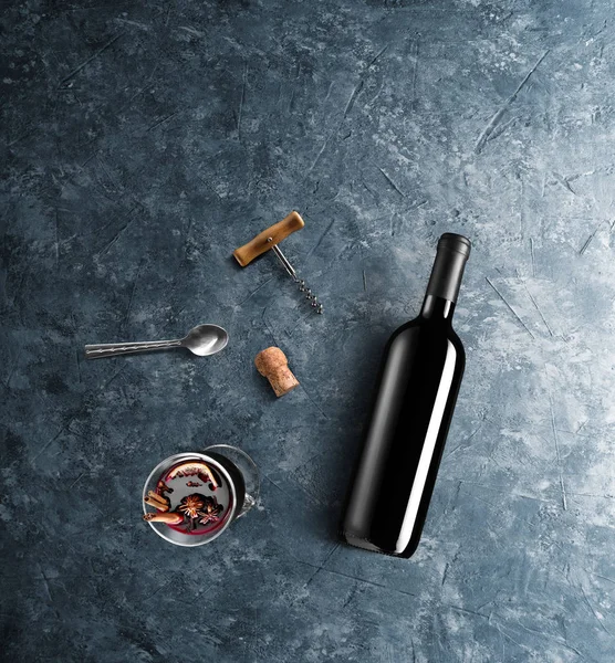 Mulled şarap tarifi Malzemeler ve mutfak aksesuarları, bir şişe kırmızı şarap, tarçın, Anason yıldız, turuncu, kahverengi bardaksoğuk baharat mavi taş zemin üzerine.