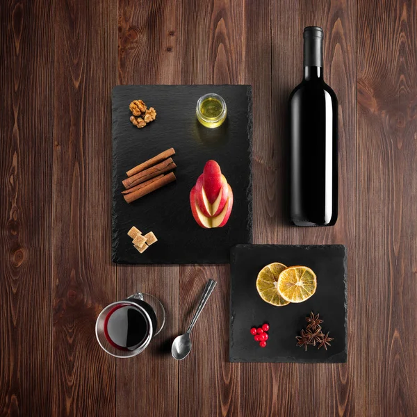 グリュー ワインのレシピの食材 キッチン アクセサリー 赤ワイン シナモン アニスの星 素朴な木製の背景にオレンジ色 茶色の砂糖とスパイスのボトル — ストック写真