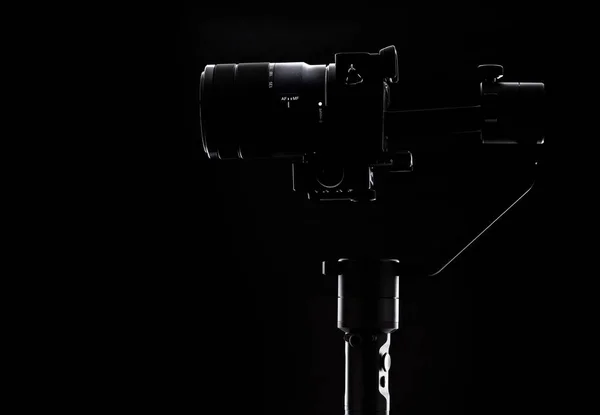 黒の背景にステディカムとカメラ。ビデオグラファーのための機器。滑らかでスローモーションビデオを撮影する場合. — ストック写真