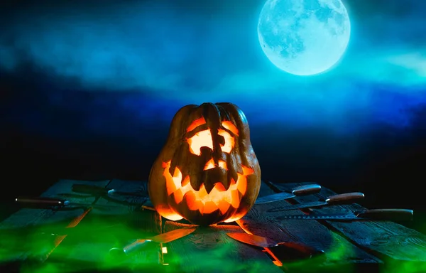 Gruselige Halloween-Kürbisse auf Holz an einem gespenstischen Ort in der Nacht. Plakatkonzept — Stockfoto