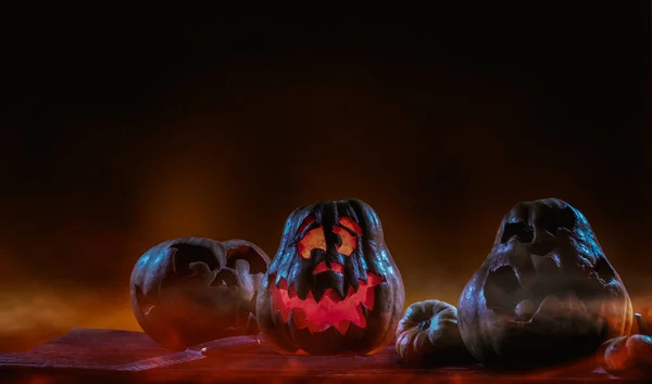 Calabazas de Halloween aterradoras en madera en un lugar espeluznante por la noche. Concepto de cartel — Foto de Stock