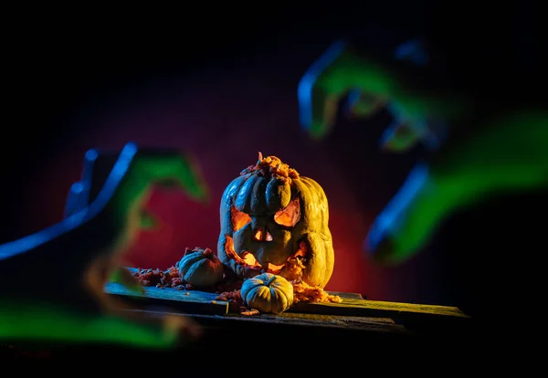 Abóboras de Halloween assustadoras com as mãos em um lugar assustador à noite . — Fotografia de Stock