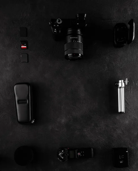 Work space videographer with laptop, digital camera, memory card, action camera, drone, remote controller, phone and camera accessory. Top view on black table background. — ストック写真