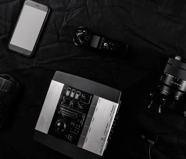 Work space videographer with laptop, digital camera, memory card, action camera, drone, remote controller, phone and camera accessory. Top view on black table background. — ストック写真